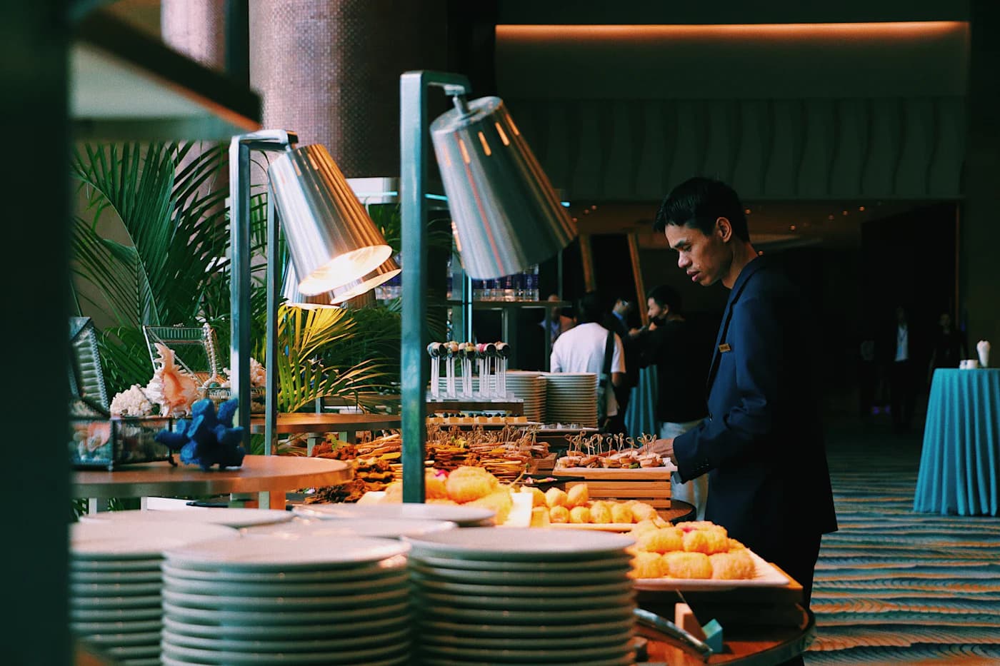 A guest choosing food at a breakfast buffet.